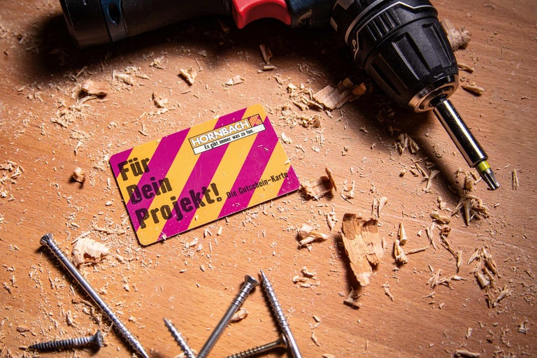 Hornbach Gutschein-Karte mit Schrauben und Akkuschrauber auf einer Holzoberfläche