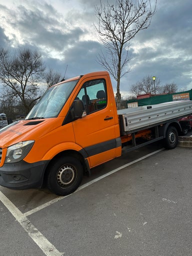 Oranger Pritschenwagen auf einem Parkplatz
