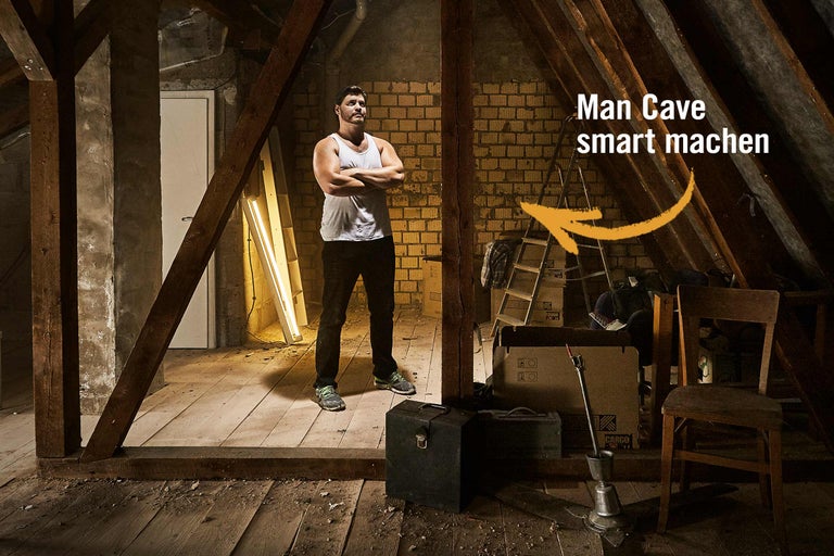Ein Mann steht mit verschränkten Armen in einem Dachzimmer, das als Heimwerkerprojekt zur "Man Cave" umgestaltet wird.