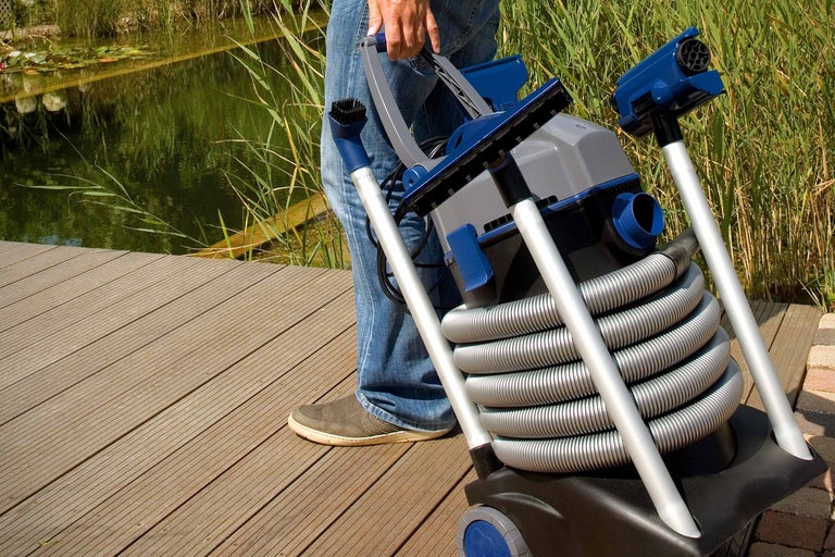 Teichsauger wird von einer Person am Teich getragen