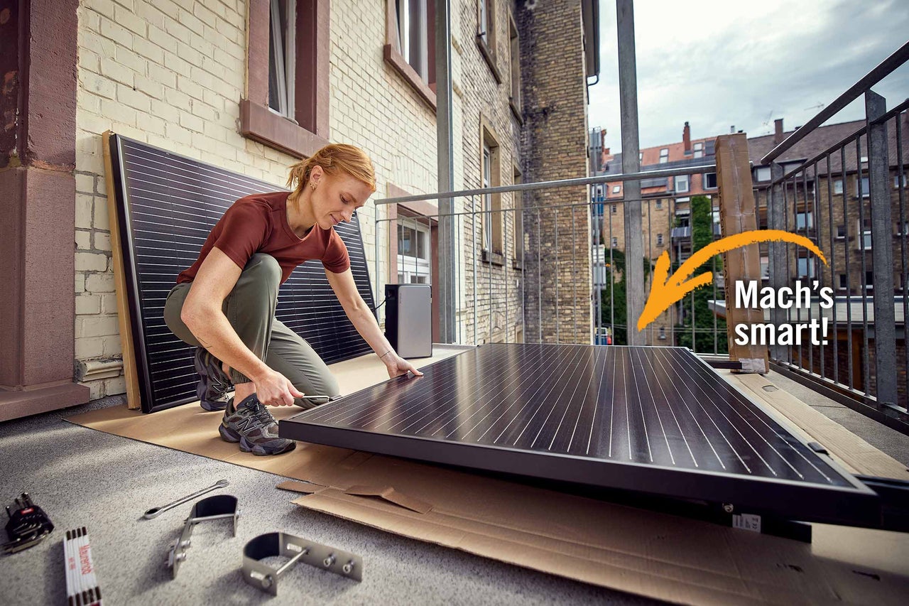 Frau installiert Solarmodul auf Balkon