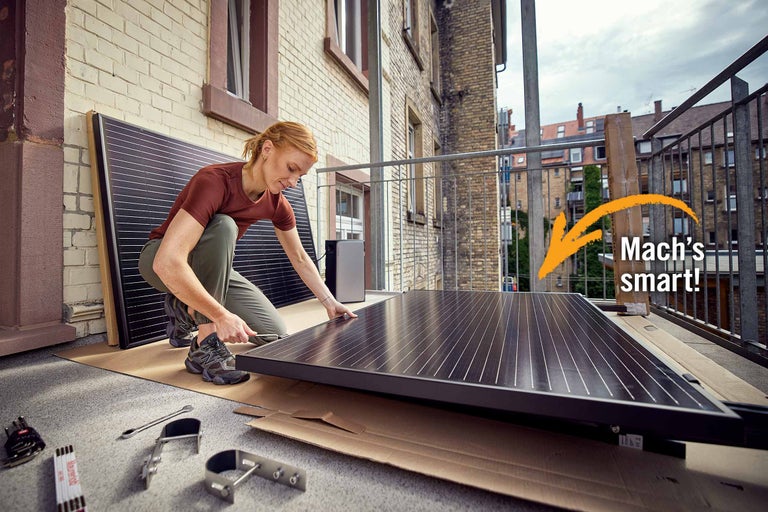 Frau installiert Solarmodul auf Balkon