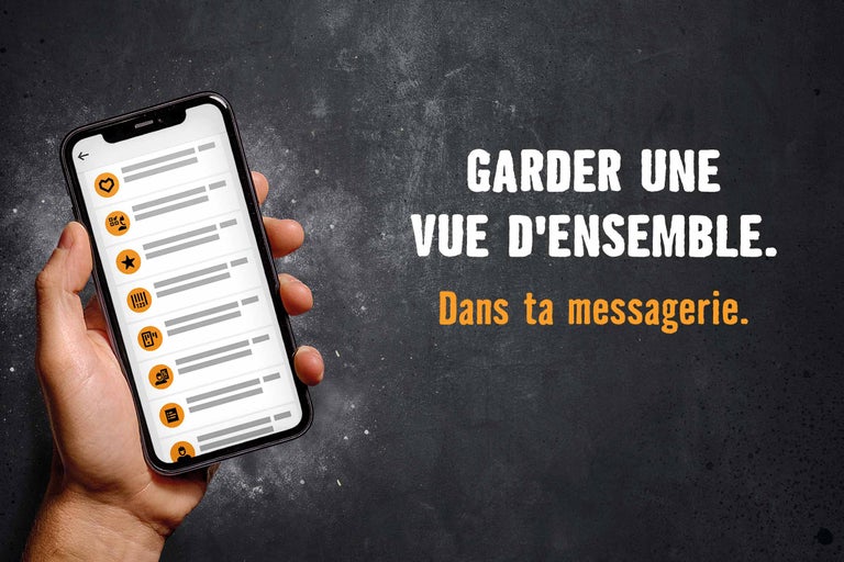 Main tenant un smartphone avec l'application Hornbach. Vue d'ensemble dans la messagerie avec le texte: Garder une vue d'ensemble. Dans ta messagerie.