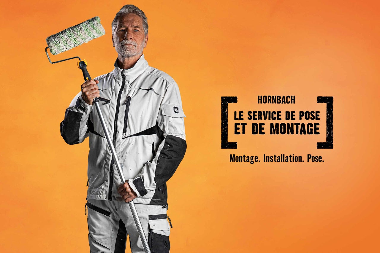 Un homme tient un rouleau à peinture devant le service de montage Hornbach.