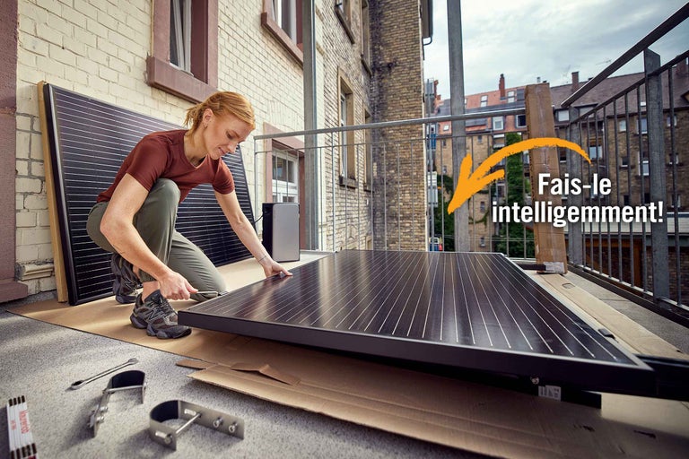 Femme installant un module solaire sur un balcon