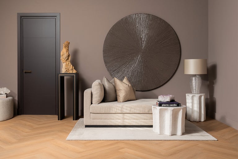 Salon moderne avec canapé, éléments de décoration, lampe, table et porte