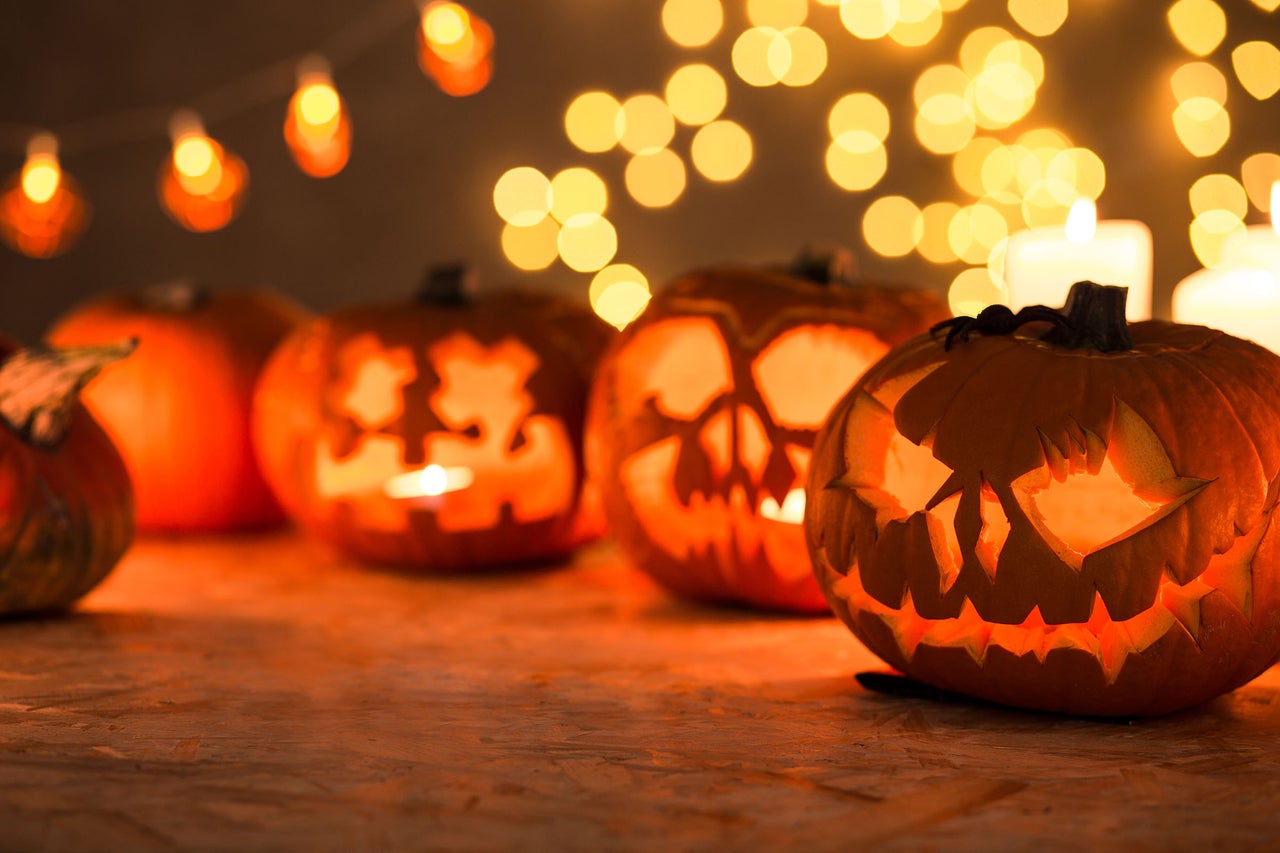 Scène d'Halloween avec des citrouilles sculptées, des bougies et des lumières