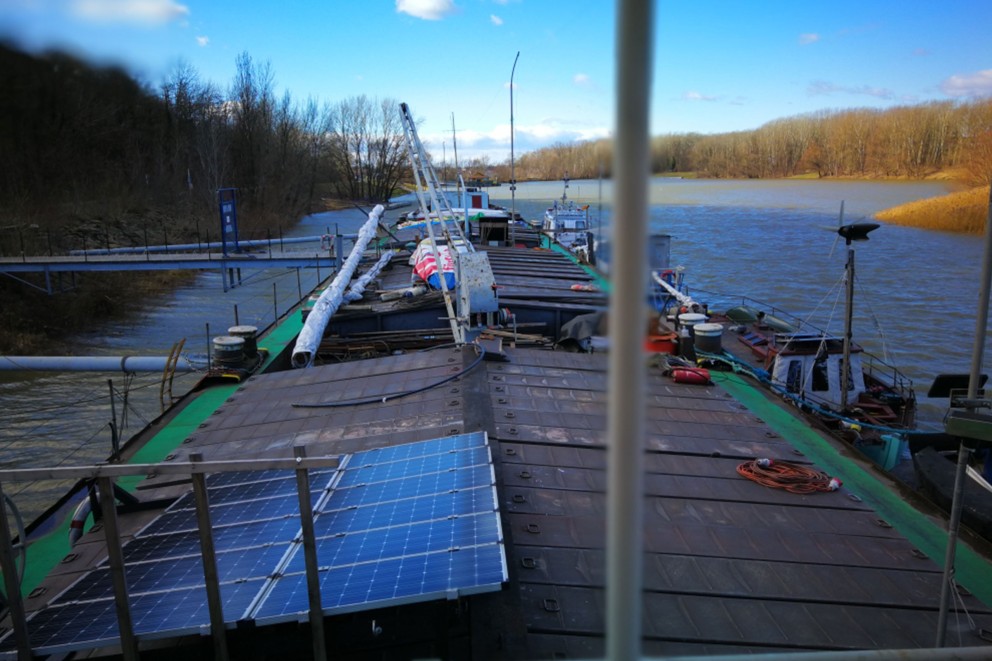 
				Solarpaneele auf dem Dach: der Werkstattkahn am Donauufer.

			