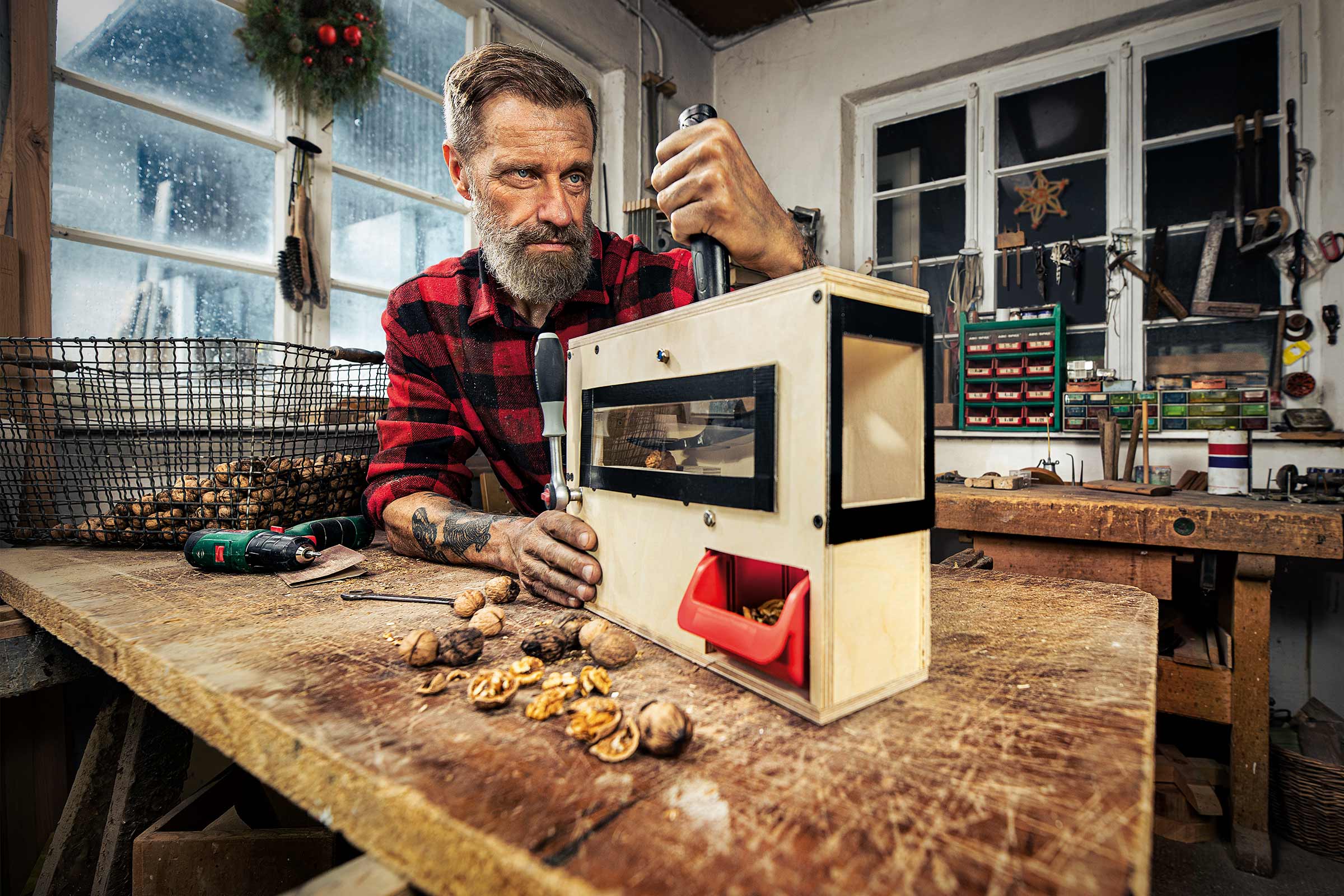 Un homme utilise un casse-noix dans un atelier.