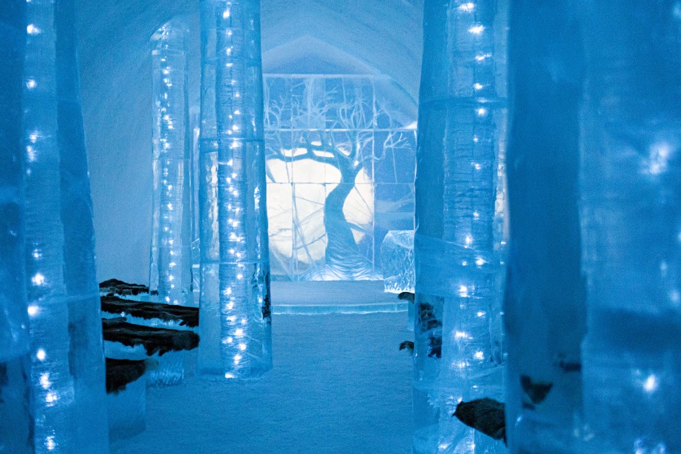 
				Der Zeremoniensaal des „Ice Hotel“ ist einem Wald nachempfunden, mit schlanken Säulen aus Eis und einem geschnitzten Baum am Ende.

			