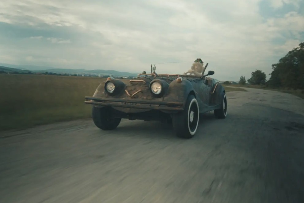 
				Vladimír Eperješi fährt in seinem Drachenwagen auf einer Straße.

			