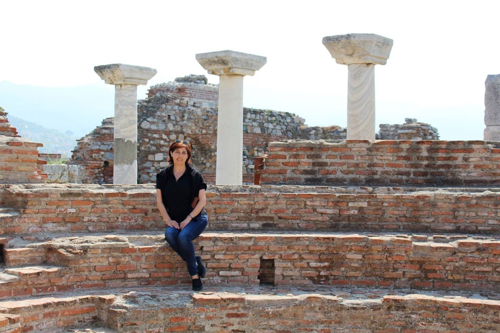 
				Frau sitzt auf Stufen von antiker Kirche in Ephesos.

			