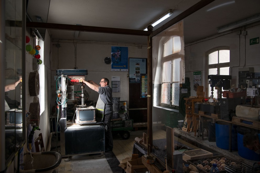 
				In der Werkstatt: Mit der Standbohrmaschine holt Stefan 20 Zentimeter lange Marmorsäulen aus dem Gestein.

			