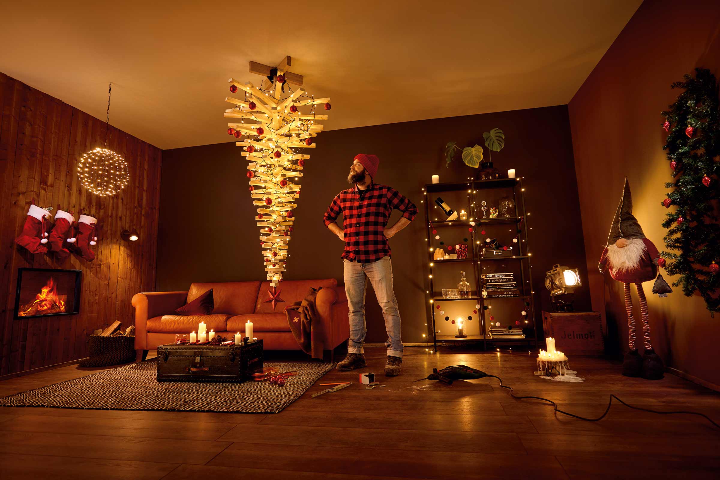 Salon confortable avec sapin de Noël inversé, cheminée et décorations pour une ambiance festive