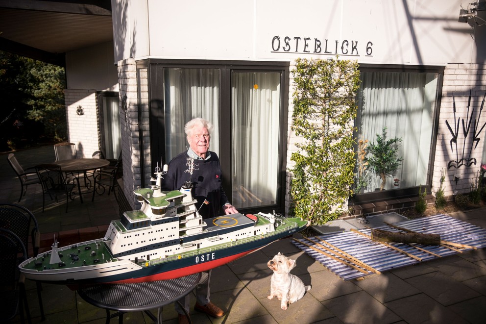 
				Lothar mit Hund vor seinem Haus mit dem Modell der „Oste“.

			