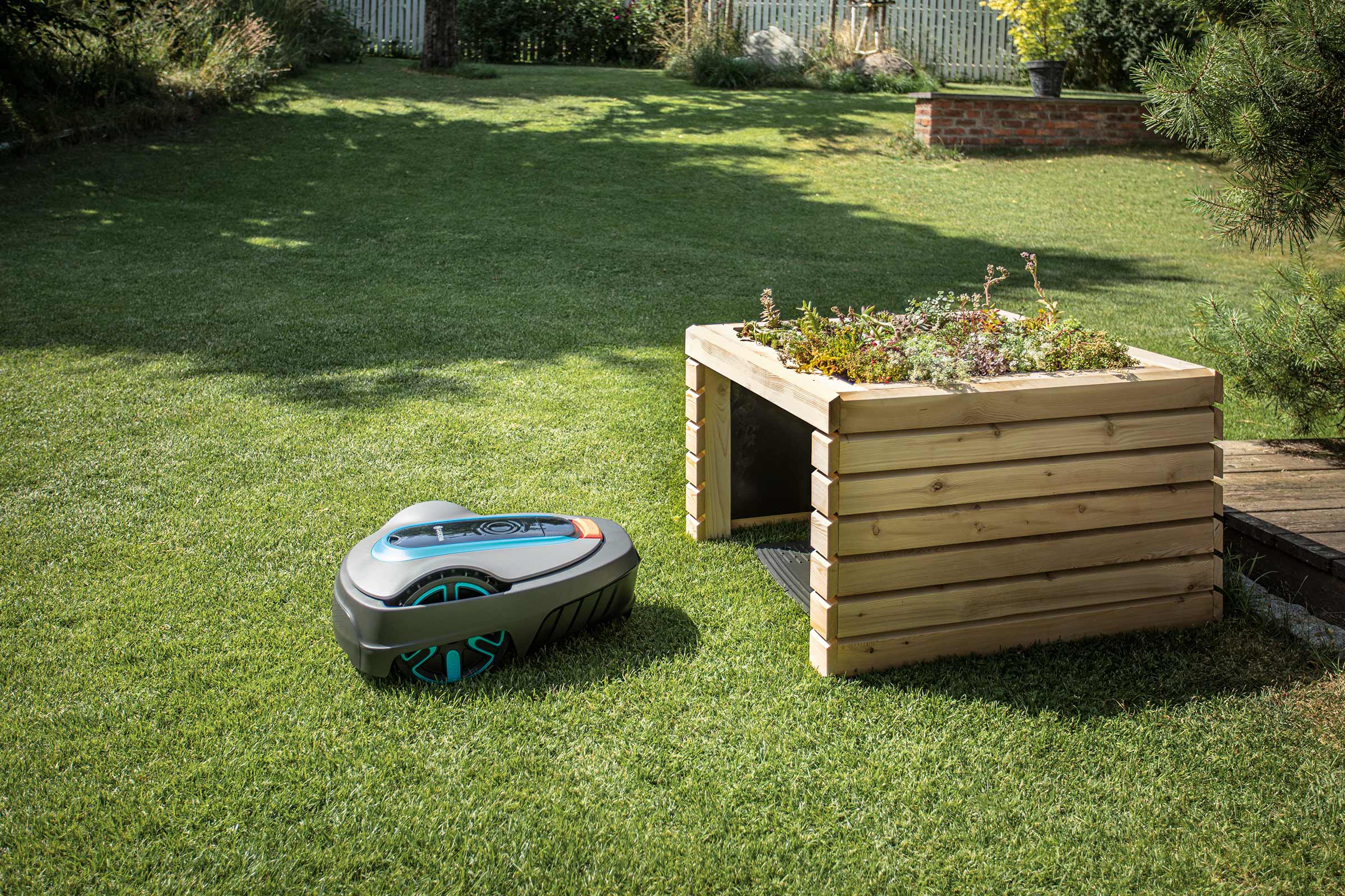 Scène de jardin avec robot tondeuse et table de plantation en bois.