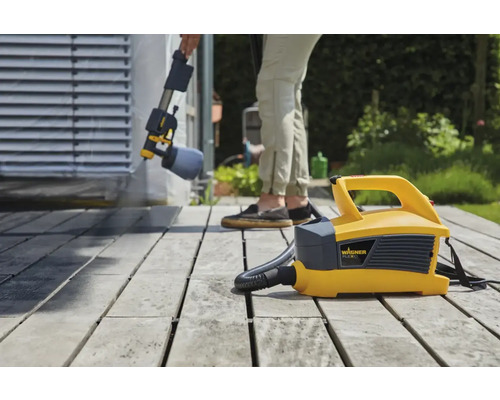 Système de pulvérisation de peinture en cours d''utilisation pour peindre une terrasse en bois