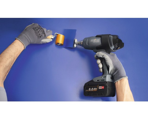 Une personne utilise un pistolet à air chaud et un rouleau de pression pour appliquer un film