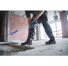 Un homme utilise un marteau-piqueur sur un chantier.