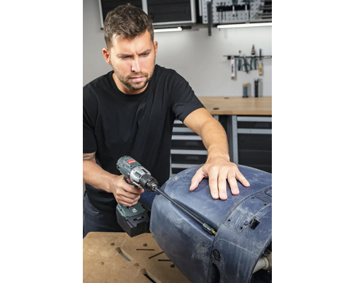 Ein Mann benutzt einen Akku-Bohrschrauber für Reparaturarbeiten an einem Bauteil.