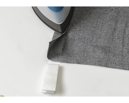 Bügeleisen auf grauem Stoff mit Bügelband