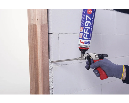 Anwendung von Brandschutzschaum mit Pistole zwischen Türrahmen und Mauerwerk