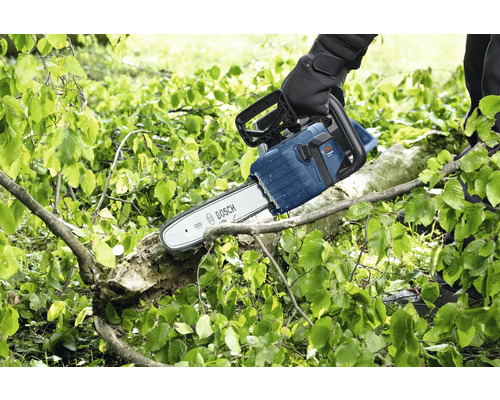 Eine Person sägt mit einer Bosch Kettensäge einen Ast.