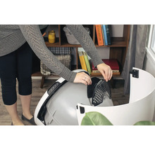 Une personne insère un filtre dans une litière automatique pour chat.