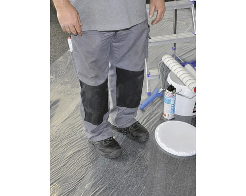 Personne en tenue de travail avec seau de peinture et rouleau à peinture