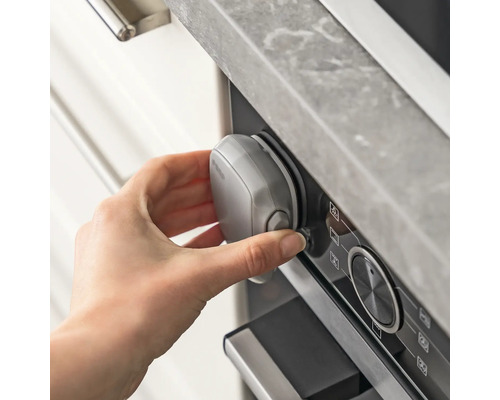 La main fixe la sécurité enfant sur le four