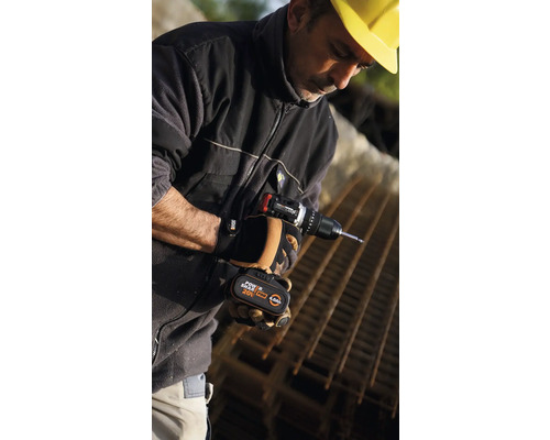 Un homme portant un casque de chantier jaune utilise une visseuse sans fil