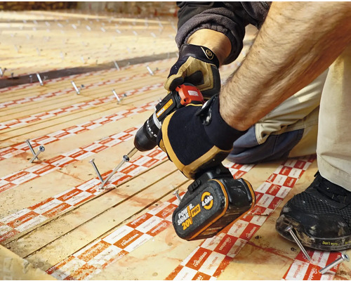 Artisan fixant une planche en bois avec une perceuse sans fil