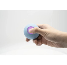 Eine Hand hält einen blauen Therapieball mit LED-Licht.