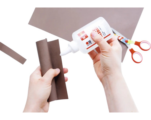 Bastelszene mit Kleber, Papier und Schere