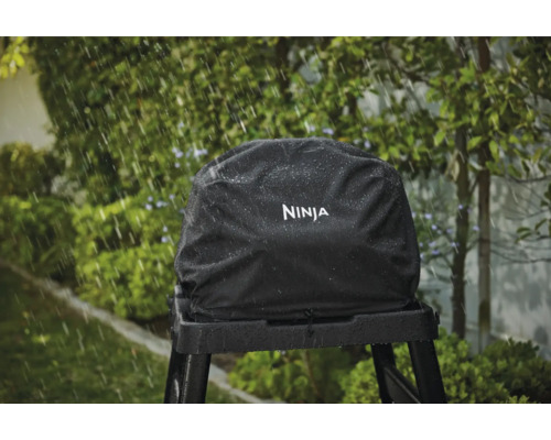 Schwarze Ninja Grillabdeckung auf einem Grillständer im Regen.