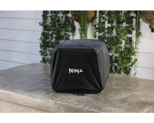 Schutzhülle für Ninja Grill auf einer Steinplatte mit Regentropfen