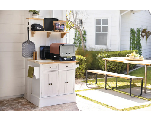 Aussenküche mit Grill, Kochutensilien und Gartentischgruppe