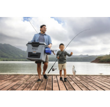 Vater und Sohn angeln mit einer Kühlbox am See