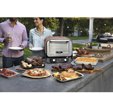 Scène avec un four d''extérieur Ninja Woodfire et divers plats préparés à l''extérieur.