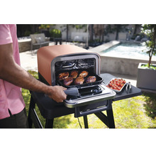 Cuisine extérieure avec four et nourriture dans le jardin.