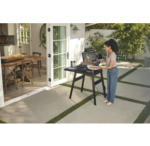 Femme avec barbecue à l''extérieur, à côté de la maison avec salle à manger