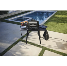 Gril électrique avec accessoires sur un poste de barbecue extérieur.