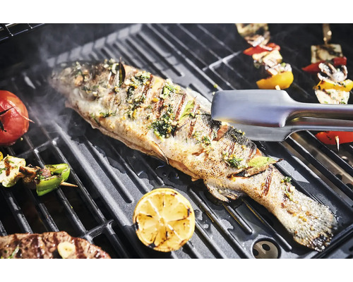 Poisson grillé avec légumes sur une grille de barbecue.
