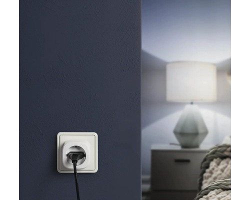 Prise électrique avec fiche branchée sur un mur dans une chambre