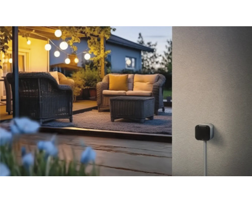Beleuchteter Aussenbereich mit Rattansitzgruppe und Aussensteckdose
