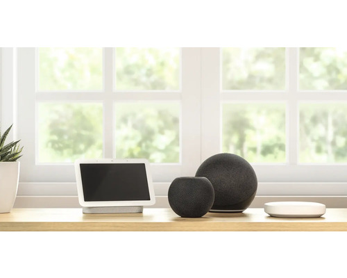 Smarte Geräte auf einem Tisch vor einem Fenster.