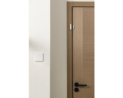 Ein hölzerner Türrahmen mit einem Sensor und einem Lichtschalter