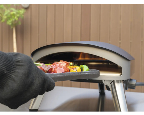 Un four de grill avec des grillades est utilisé avec un gant.