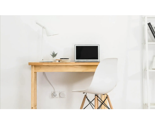 Bureau avec ordinateur portable, lampe et chaise de bureau dans une pièce lumineuse