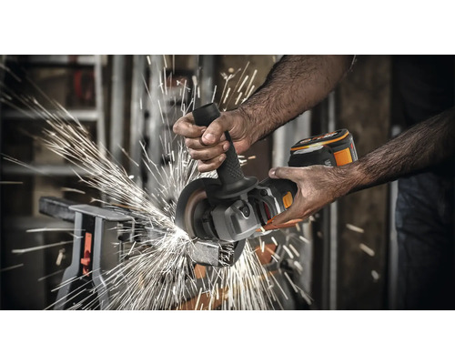 Une personne utilise une meuleuse d''angle sans fil pour couper du métal, produisant des étincelles.